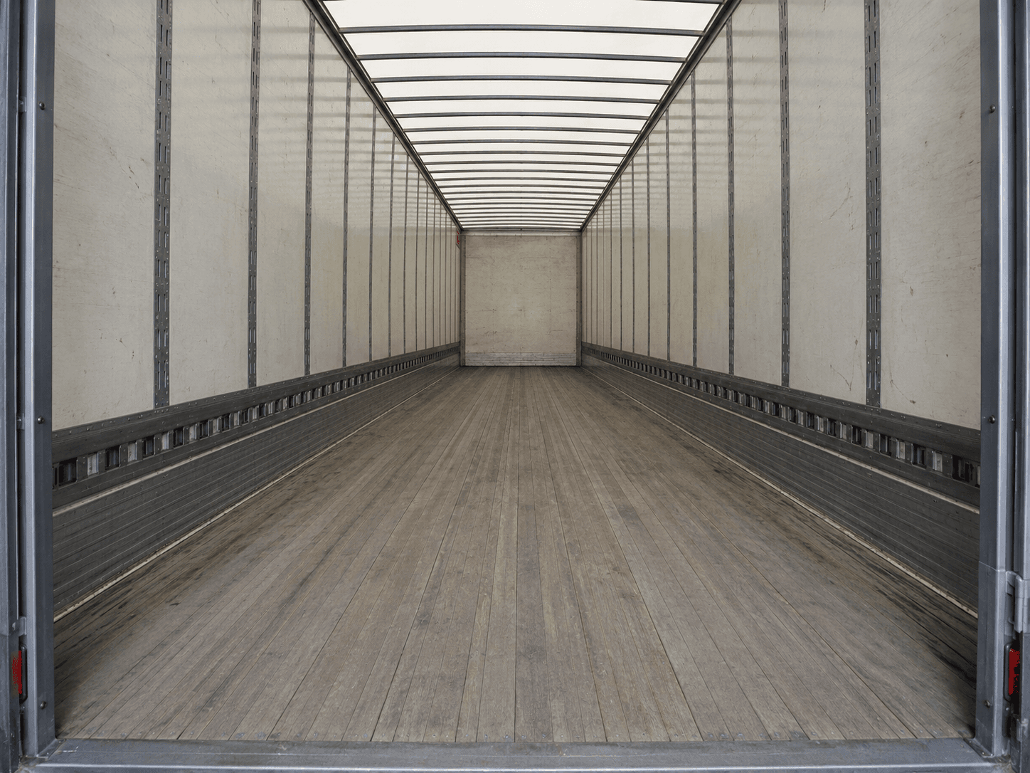 Empty dry van interior looking forward from the open rear doors toward the nose