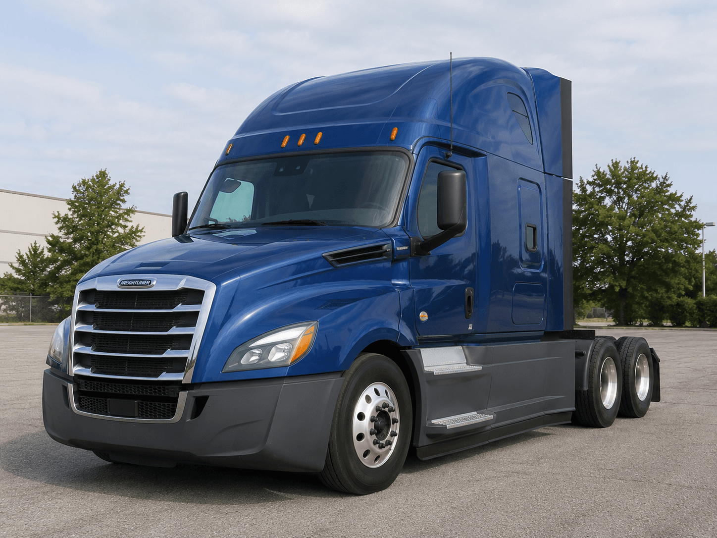 Blue Freightliner sleeper tractor parked on pavement, three-quarter front view